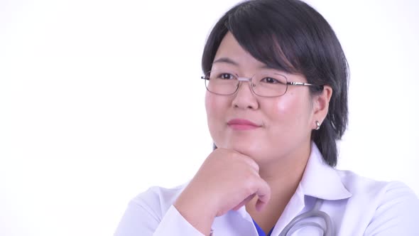 Face of Happy Overweight Asian Woman Doctor Thinking and Looking Up