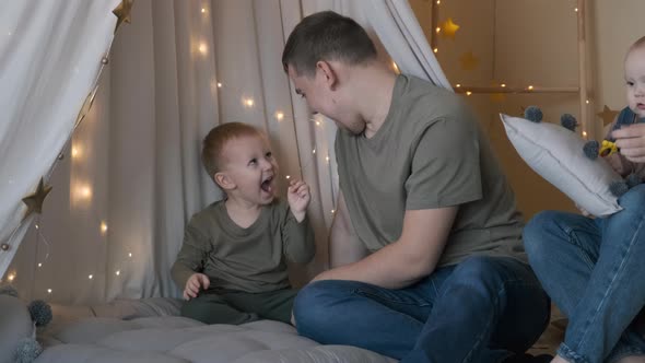 Happy Father Playing with 2Year Old Son Indoors