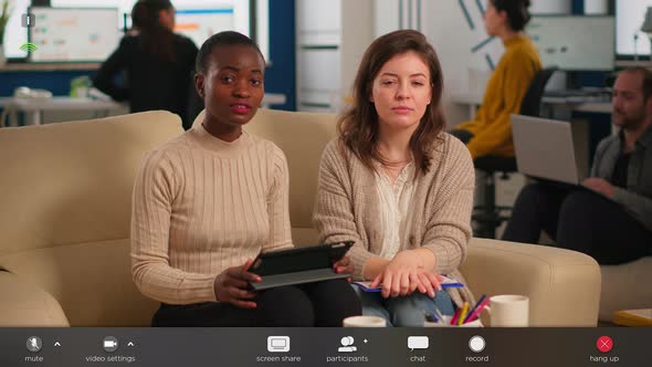 Multiethnic Team Talking During Video Meeting Sitting on Couch