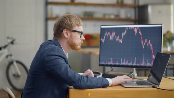 Business Man Working with Trader Graphics on Monitors at Home