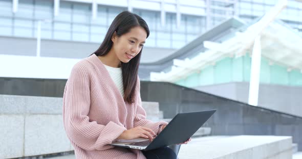 Woman working on laptop computer at outdoor