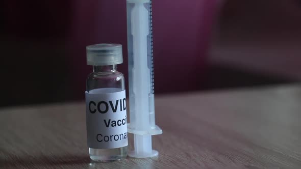 Coronavirus Vaccine Vial And Syringe. On The Surface Of The Table. Camera Zoom. Close Up.