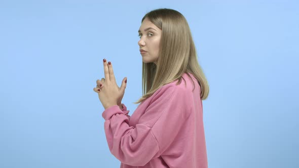 Slowmotion of Attractive Young Woman Standing in Profile with Gun Gesture Acting Like Secret Agent