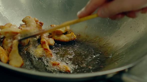 Close Up Cooking Fried Potatoes in Oil Pan Mixes Them By Wooden Spatula