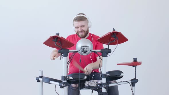 Hobby and Music Concept. Young Man Having Fun Playing Electronic Drum Kit At Home