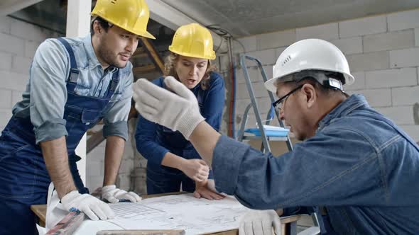 Construction Workers Discussing Floor Plans