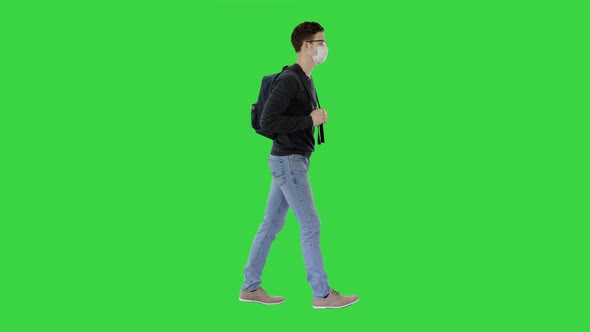 Student in Protective Masks Walking with Backpack on a Green Screen, Chroma Key.