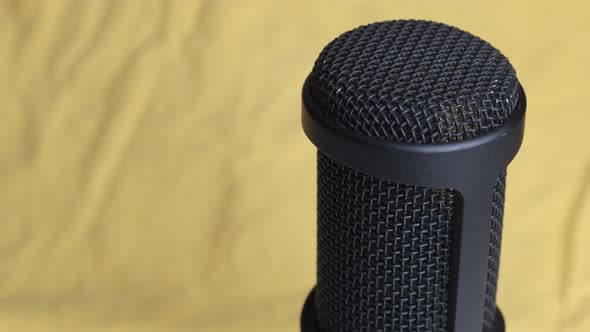 Studio Condenser Microphone Rotates on Yellow Background with Place for Text