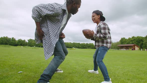 Joyful Black Family Playing American Football on Green Field