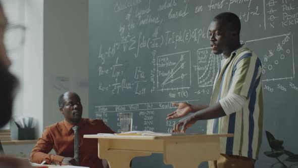 African American Student Explaining Formulas on Blackboard