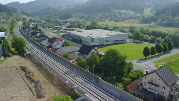 Family houses between main road and railroad with big shopping centrum in background. Aerial 4k view