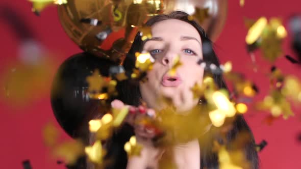 Happy Woman Blowing Gleaming Confetti To Camera