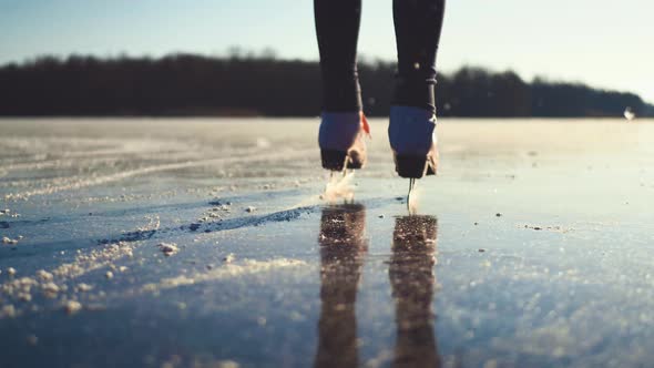 Young Woman Ice Skating on a Frozen Lake on a Freezing Winter Day. Legs of Skater on Winter Ice Rink