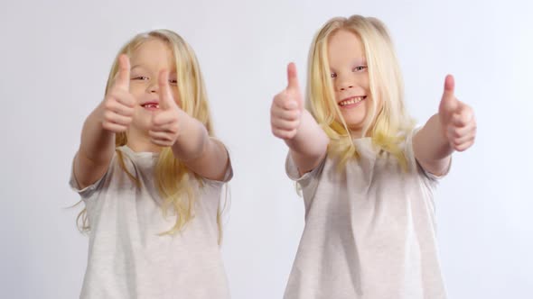 6-year-old Twins Posing with Thumbs Up