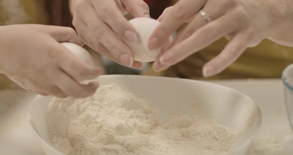 Extreme Close-up of Plate with White Flour. Adult Female Caucasian Hands Breaking Egg, Little Girl