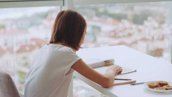 Cheerful handsome girl doing homework