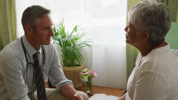 Doctor helping senior woman in her room of retirement house