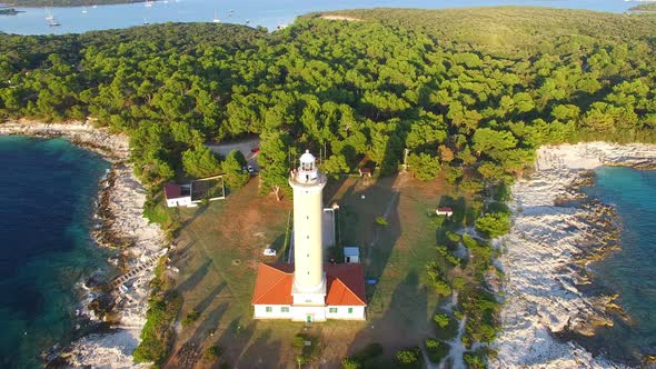 Flying over lighthouse, Croatia with a forest in the background