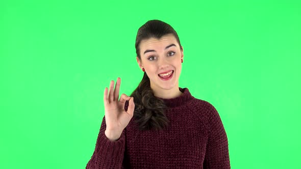 Smiling Girl Makes Sign Ok. Green Screen