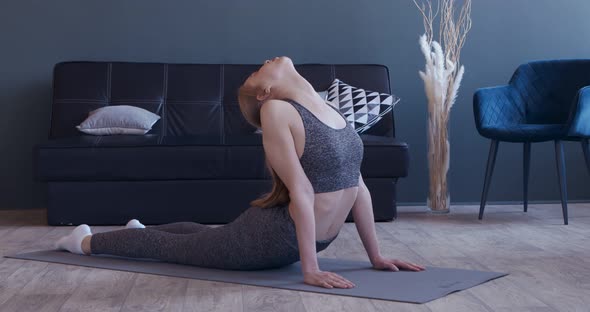 Slim Girl Stretching Lower Back on Mat, Practicing Cobra Pose