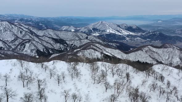 aerial panoramic of snowy mountain peak range in nagano japan during cloudy day