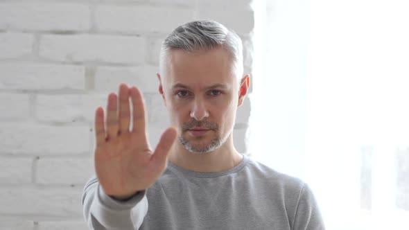 Stop, Gesturing by Middle Aged Man Sitting in Office