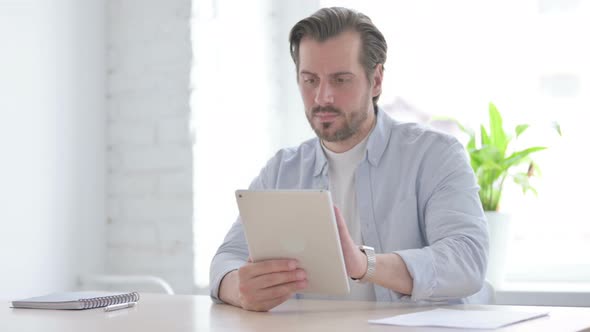 Young Man Reacting to Loss on Tablet in Office