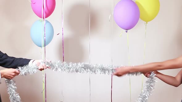 Couple playing tug of war with shiny brace string