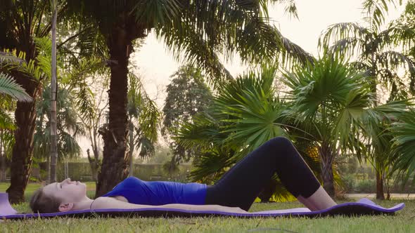 Fitness Woman Doing Glute Bridge Workout Exercise on Sports Mat in Park