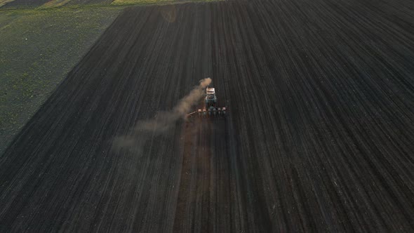 Aerial View of Farmer in Tractor Preparing Land for Sowing at Sunrise