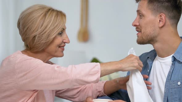 Caring Mother Attaching Napkin to Neck of Son Before Tea Drinking Overprotection