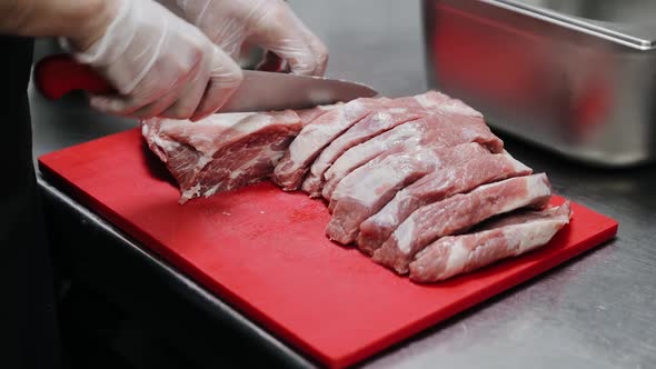 Beef fillet on the Cut Board, preparing Meat. Male Hands with a Knife slicing, cutting beef meat