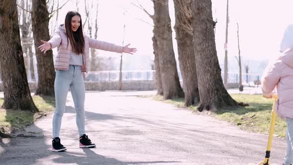 The Mother and Cute Daughter Are Walking in the Park