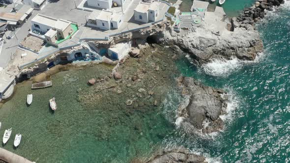 Scenic Little Greek Fishing Village with Typical White Houses and Boats in the Bay