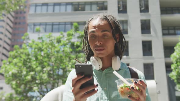 Mixed race man using his phone outside