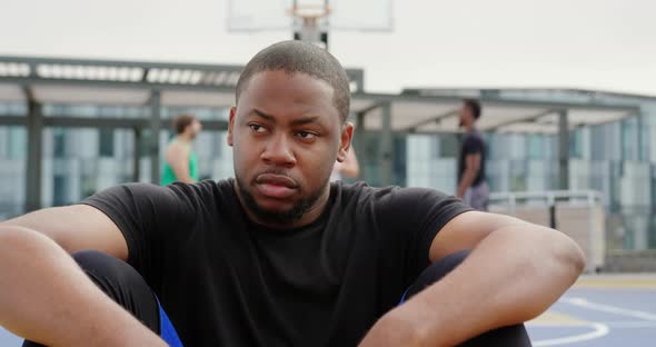 Basketball player sitting in basketball court 4k