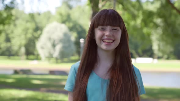 Medium Shot of Cheerful Preteen Girl Looking at Camera Outdoors