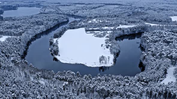 Aerial view of winter nature. Winter river and snowy forest.
