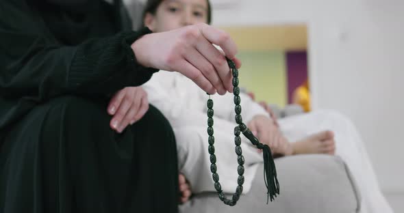 Muslim Woman Praying at Home with Kid in Background