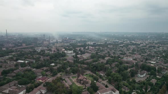 Aerial View of the City Near a Large Industrial Plant with Pipes and Smoke