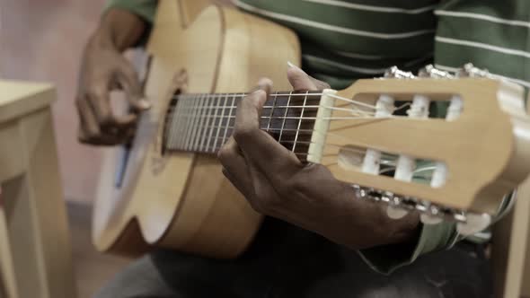 Man playing guitar at home