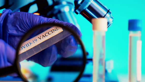 Doctor in Protective Gloves Holds Ampoules Covid19 Vaccine on a Laboratory Bench