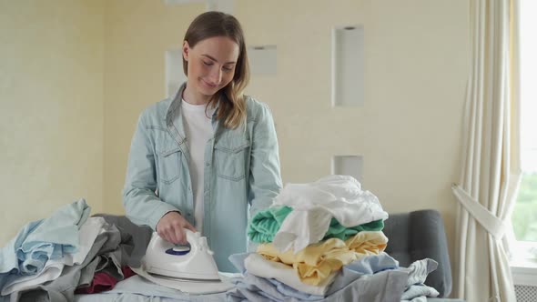 Happy Woman Ironing Her Clothes at Home