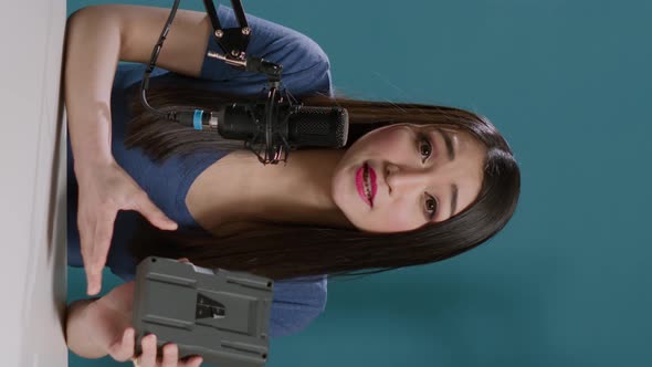 Vertical Video POV of Asian Woman Doing Product Review with v Mount Battery