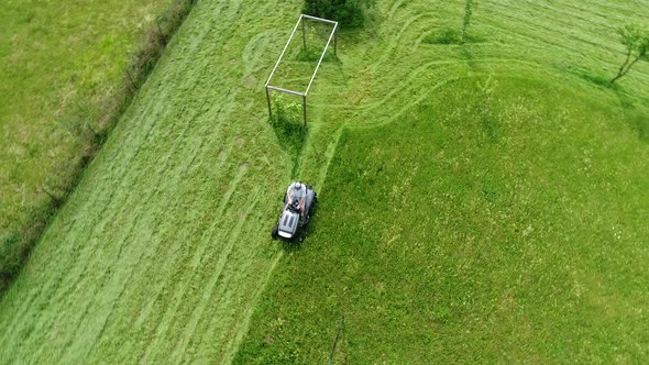 Riding lawn mower in action seen from the sky