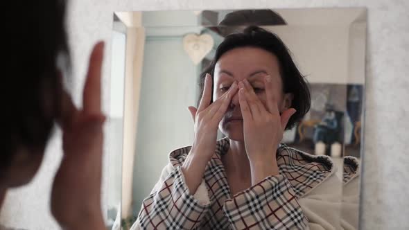 Portrait Of Beautiful Healthy Woman Putting Moisturizing Cream On Face