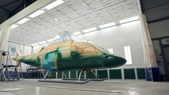 Military or Civilian Helicopter Stands in Spray Booth and is Painted Khaki Green