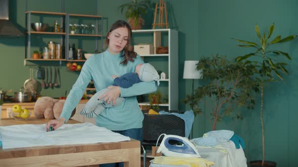 Tired Mom Soothing Her Crying Child on the Hands