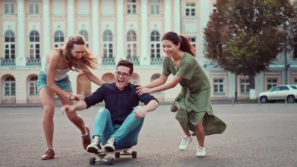 Cool Young Girls and Guy Longboards and Skateboards Through Stylish Hip Cultural Part of the City