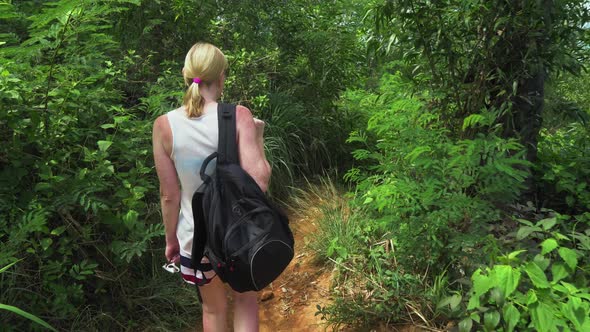 tourist girl is traveling along a tropical island. walking through the rainforest